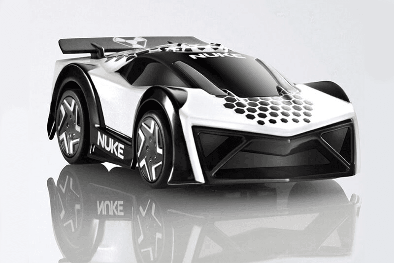 Black and white Nuke toy race car with a rear spoiler, reflected on a glossy surface