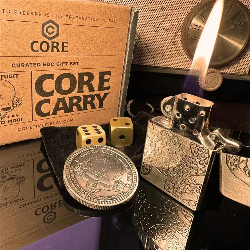 Core Carry gift set with an engraved lighter, brass dice and a skull coin in front of its kraft box